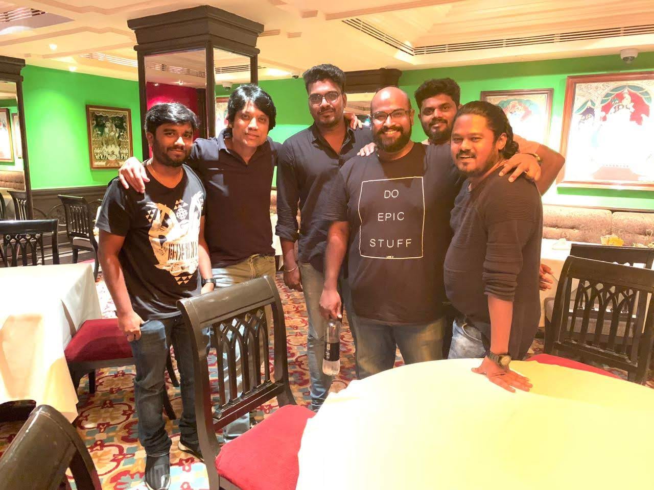 Six of the team together indoors on a dressed interior set
